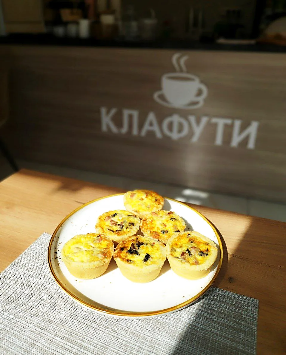 Мини-киши на тарелке на фоне вывески КЛАФУТИ